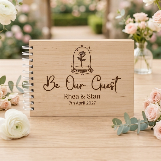 Wooden guestbook with 'Be Our Guest' engraved on the front.