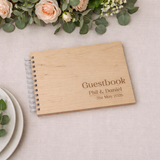Sign in guest book for wedding on a white table cloth at a wedding with a floral centre piece.