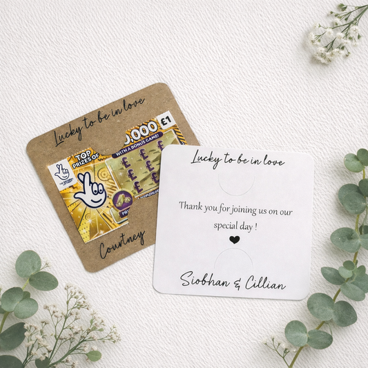 Personalised wedding favour tickets on a white background with greenery