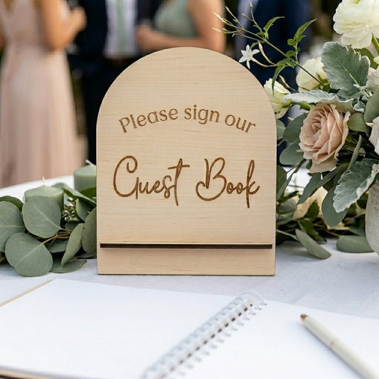 Modern arch guest book sign on a wedding table with guests behind