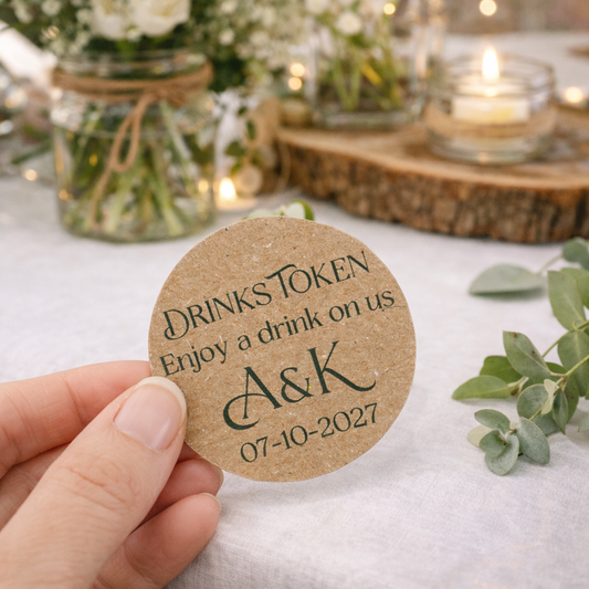 a personalised drink tokens for wedding with custom initials and wedding date on brown card. In the background, a warm floral display