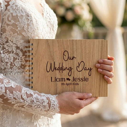 Wooden wedding guest book with 'Our Wedding Day' engraving held by a person in a lace dress.