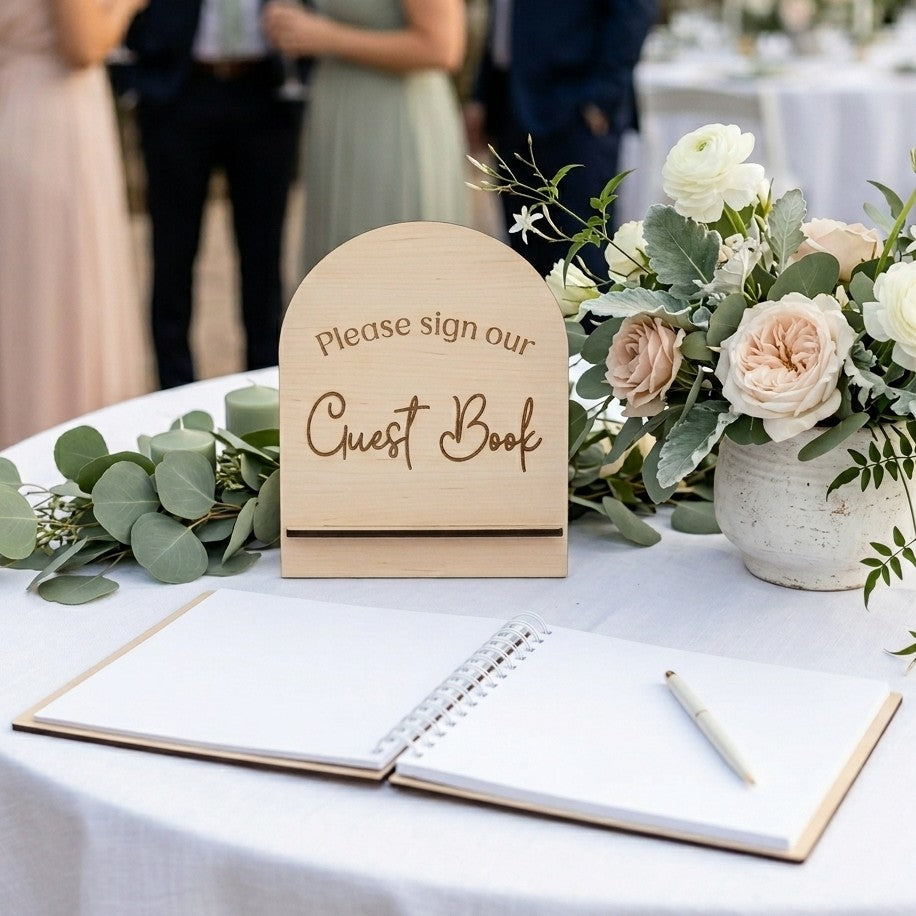 wood wedding guest book sign on a white wedding table outdoors. 