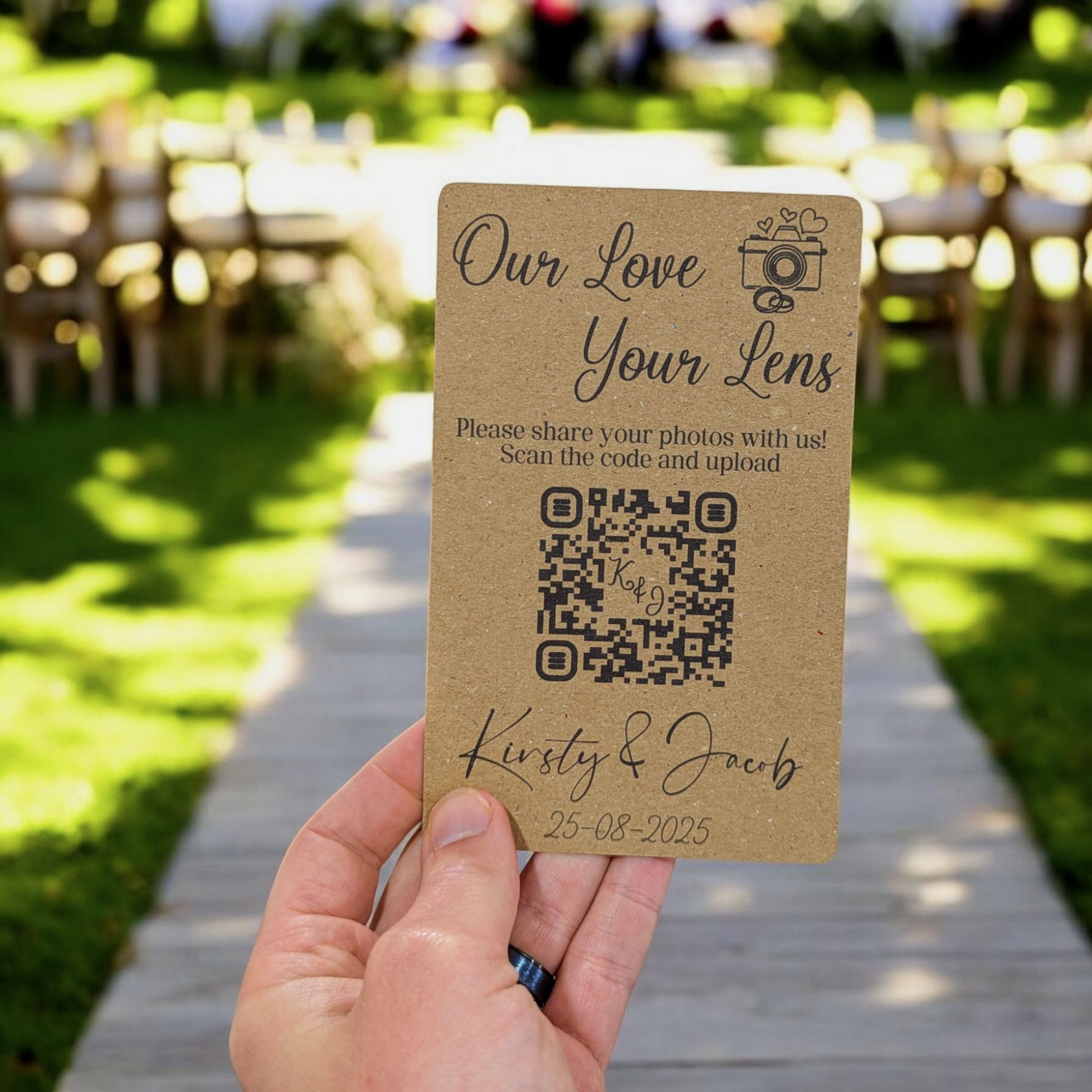 Hand holding a wedding QR code card with a garden wedding background