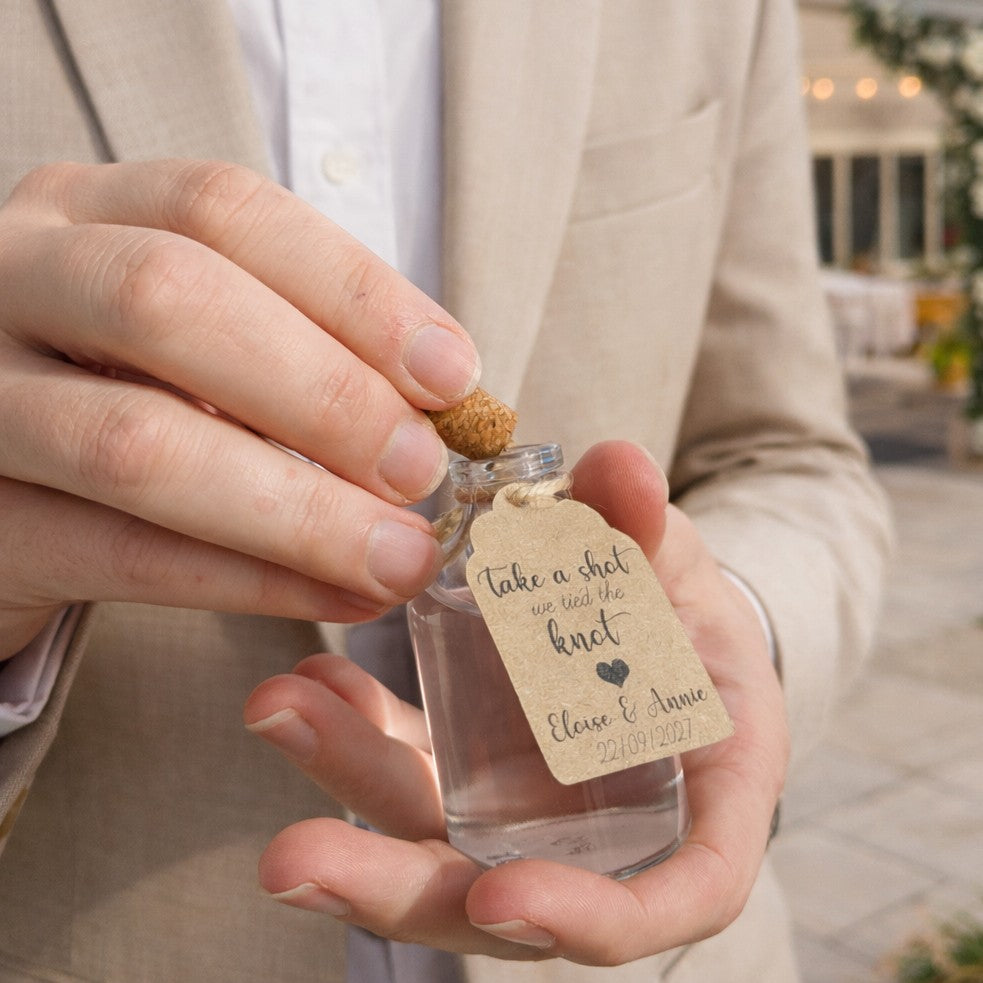wedding guest holding bottle wedding favour at an outside wedding venue